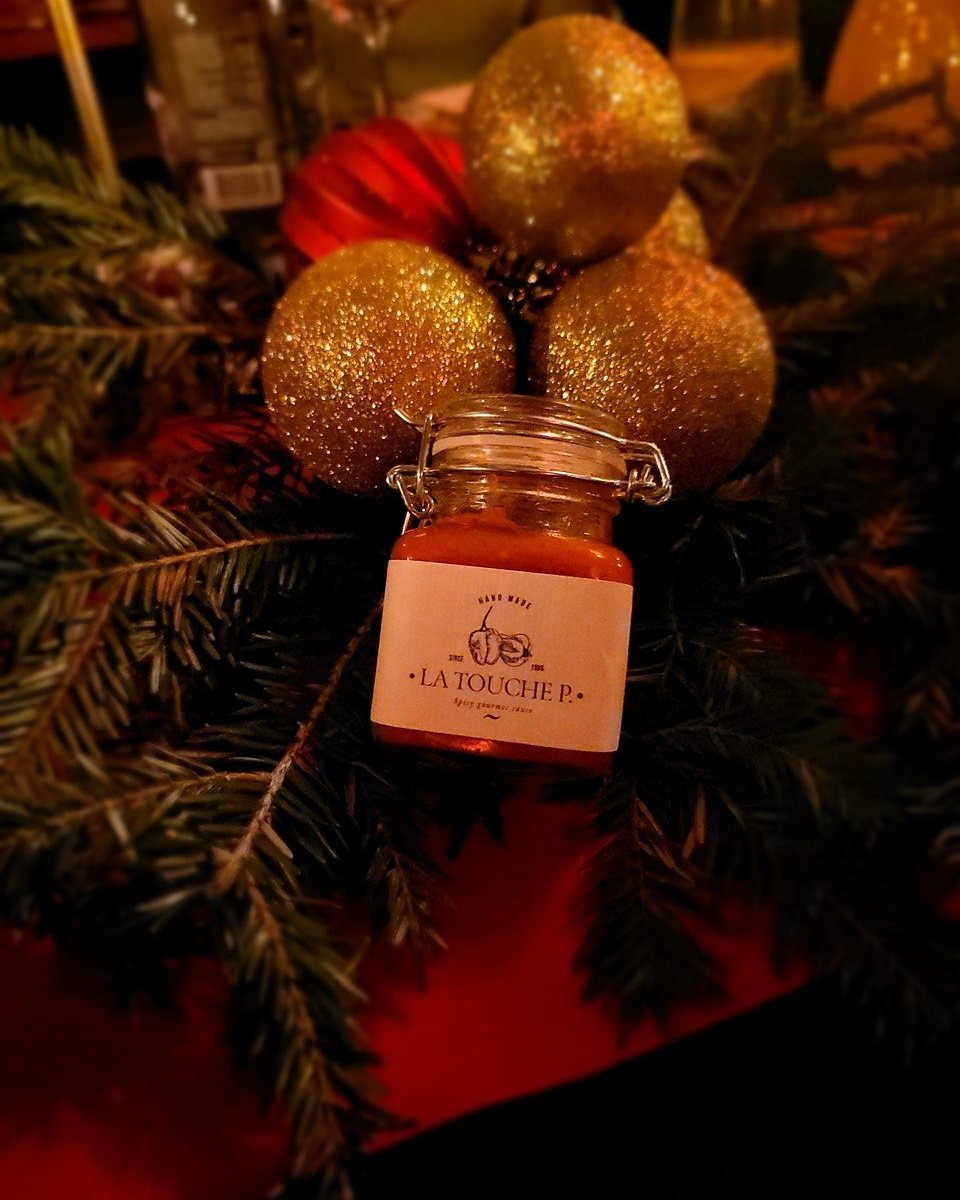 Glas La Touche P. zwischen goldenen Weihnachtskugeln und Tannenzweigen